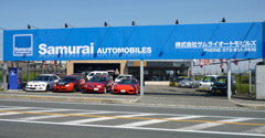 青い看板のお店がサムラーオートモビルズです！